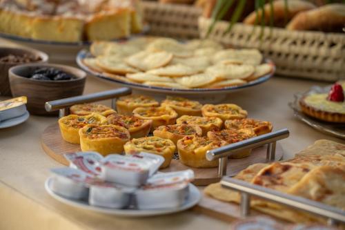a table filled with different types of pastries and pies at Riad Atlas Palace & SPA in Marrakech