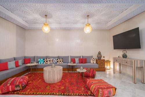 a living room with a couch and a flat screen tv at Riad Atlas Palace & SPA in Marrakech