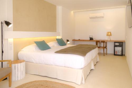 a bedroom with a large white bed with blue pillows at Sorraia Hotel Rural in Santa Justa
