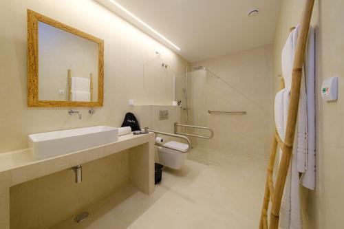 a bathroom with a sink and a toilet and a mirror at Sorraia Hotel Rural in Santa Justa