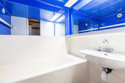 La salle de bains est pourvue d'un lavabo blanc et d'un plafond bleu. dans l'établissement Résidences quartier Charmettoger - maeva Home - Studio 4 Personnes Confort MAE-0809, à Arc 1800