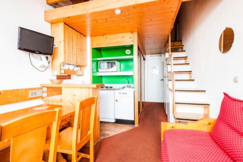 une petite cuisine avec une table et une salle à manger dans l'établissement Résidences quartier Charmettoger - maeva Home - Studio 5 Personnes Budget MAE-0813, à Arc 1800