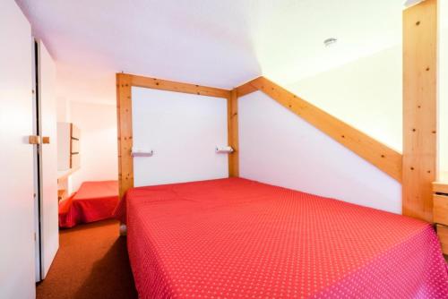 une chambre avec un lit rouge dans une pièce dans l'établissement Résidences quartier Charmettoger - maeva Home - Studio 5 Personnes Budget MAE-0813, à Arc 1800