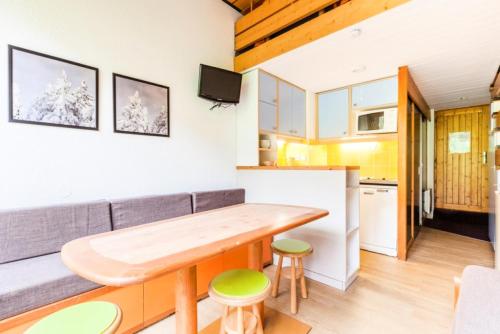 une cuisine et un salon avec une table et un canapé dans l'établissement Résidences quartier Charmettoger - maeva Home - Studio 6 Personnes - Confort MAE-0820, à Arc 1800