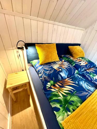 Una cama en una habitación con almohadas amarillas. en Bałtycka Strefa, en Władysławowo