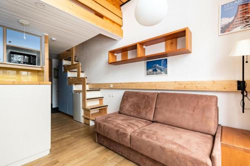 un salon avec un canapé et un escalier dans l'établissement Résidences quartier Charmettoger - maeva Home - Studio 6 personnes - Confort MAE-0821, à Arc 1800
