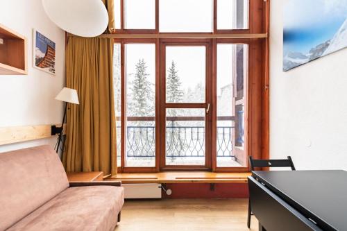 un salon avec une grande fenêtre et un canapé dans l'établissement Résidences quartier Charmettoger - maeva Home - Studio 6 personnes - Confort MAE-0821, à Arc 1800