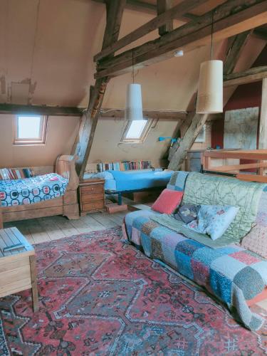 un salon avec un canapé et un lit dans l'établissement maison familiale au cœur du cotentin, à Valognes