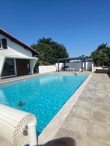 une piscine devant une maison dans l'établissement VILLA DOMAINE du DOUC, à Liposthey