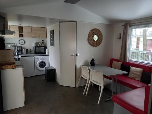 une cuisine et un salon avec une table et des chaises dans l'établissement Mobil Home 2 chambres avec terrasse, à Saint-Hilaire-de-Riez