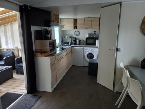 - une cuisine avec lave-linge et sèche-linge dans la chambre dans l'établissement Mobil Home 2 chambres avec terrasse, à Saint-Hilaire-de-Riez