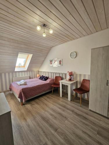 a bedroom with a bed and a table and chairs at Pokoje Gościnne Pod Lipami in Kudowa-Zdrój