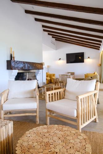 a living room with two chairs and a fireplace at Sorraia Hotel Rural in Santa Justa