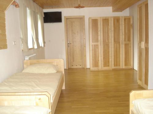a bedroom with two beds and a wooden floor at Farmstay Hiša Pečovnik in Luče