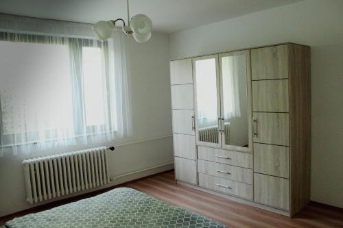 a bedroom with a large cabinet and a window at U Potoka in Brlohy