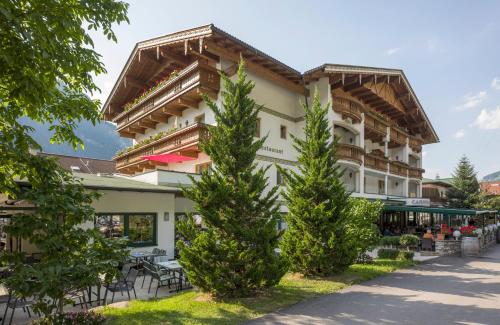 a hotel with two trees in front of it at Landhotel Denggerhof in Mayrhofen