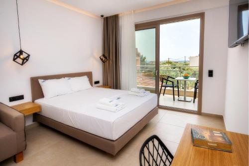 a bedroom with a bed and a table and a balcony at Calma Living in Potos
