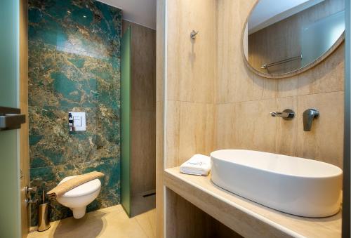 a bathroom with a sink and a toilet and a mirror at Calma Living in Potos
