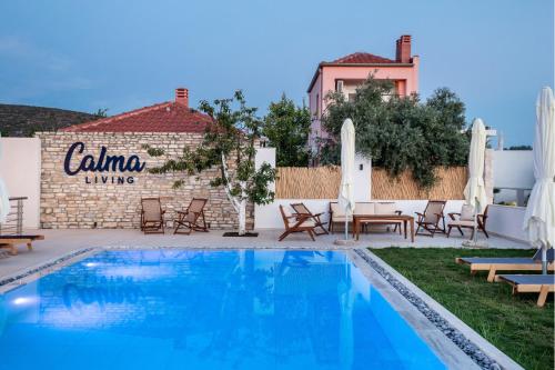 a swimming pool with chairs and a building at Calma Living in Potos