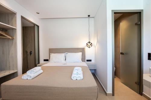 a bedroom with a large bed with towels on it at Calma Living in Potos