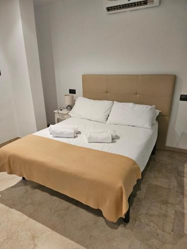 a bedroom with a large bed with two towels on it at El Ático in Alicante
