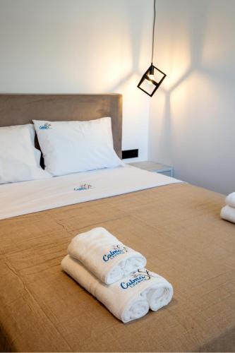 two towels are sitting on top of a bed at Calma Living in Potos