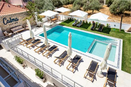 an overhead view of a swimming pool with chairs and umbrellas at Calma Living in Potos