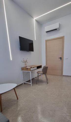 a room with a desk and a door and a table at La Peonia B&B in Ragusa