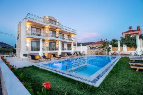 a hotel with a swimming pool in front of a building at Calma Living in Potos