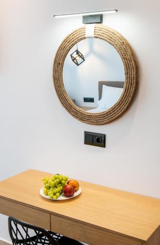 a plate of fruit on a table with a mirror at Calma Living in Potos