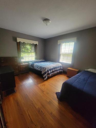 a bedroom with two beds and a wooden floor at Cozy Apartment in Historic East Knoxville in Knoxville