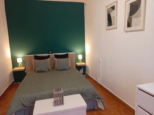 - une chambre dotée d'un lit avec un mur vert dans l'établissement appartement aulus les bains, à Aulus-les-Bains