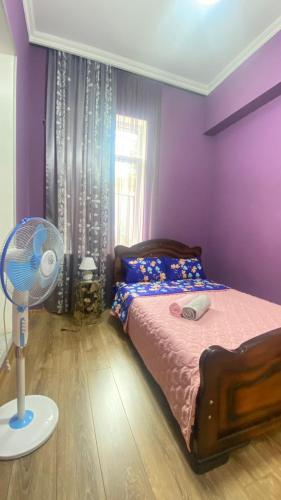 a purple bedroom with a bed and a fan at Panorama City Kutaisi in Kutaisi