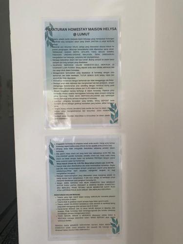 a display case with a sign on a white wall at Maison Helysa Homestay in Lumut