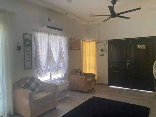 a living room with a couch and a ceiling fan at Maison Helysa Homestay in Lumut
