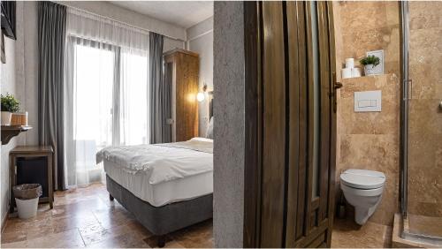 a bathroom with a bed and a toilet in a room at Selora Vama Veche in Vama Veche