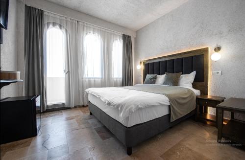 a bedroom with a large bed and two windows at Selora Vama Veche in Vama Veche