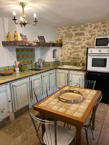 - une cuisine avec une table en bois et une cuisinière dans l'établissement Chez Dragos centre ville Lauris, à Lauris