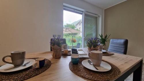 a wooden table with plates and cups on top of it at Casa Lina Tirano in Tirano