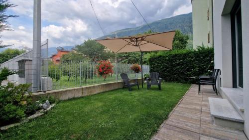 a patio with a table and chairs and an umbrella at Casa Lina Tirano in Tirano