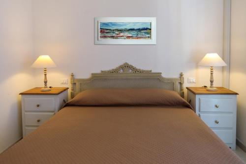 een slaapkamer met een bed met 2 dressoires en 2 lampen bij Appartamento Panoramic in Lerici