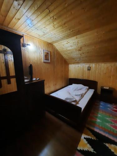 a bedroom with a bed in a wooden room at Casa ALINA ȘI ANDREEA in Arieşeni