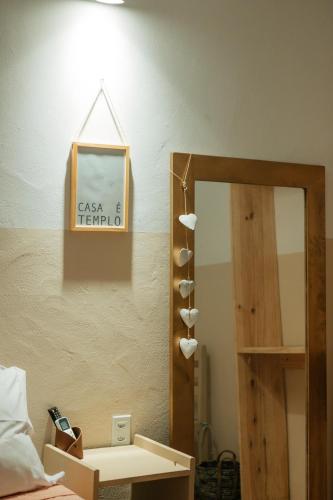 a mirror in a bedroom next to a bed with a shelf at Pousada Girassol Morro de São Paulo in Morro de São Paulo