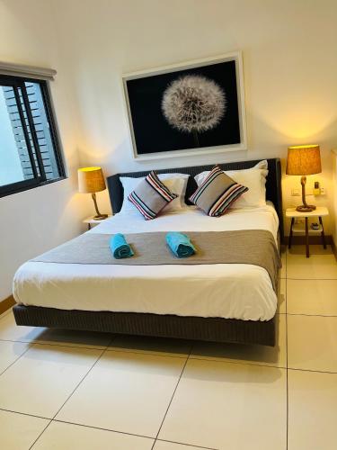 a bedroom with a large bed with two pillows at SPECIAL OFFER Prime Seafront Apartment in Latitude, Black River 100 Mbps fast internet connection in Rivière Noire
