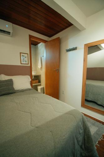 a bedroom with a large bed and a mirror at Pousada Girassol Morro de São Paulo in Morro de São Paulo