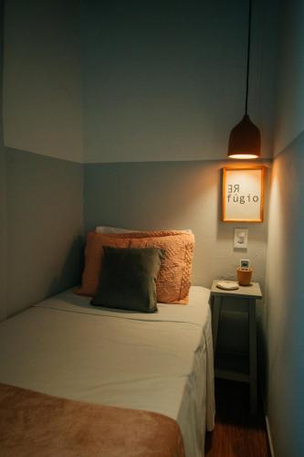 a bedroom with a bed and a table with a clock on the wall at Pousada Girassol Morro de São Paulo in Morro de São Paulo