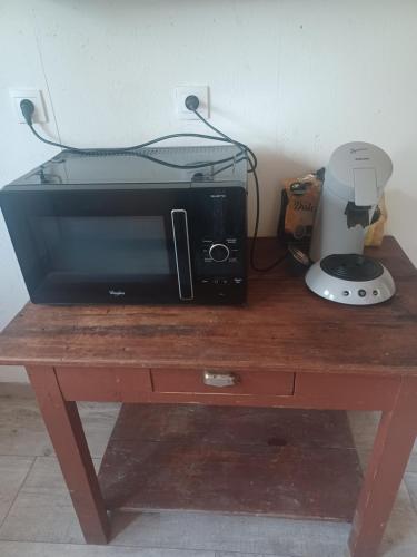 a microwave sitting on top of a wooden table at maison en ville au calme in Fleurance