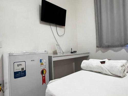a room with a bed and a tv on the wall at Casa de Hóspedes 2Q até 6 pessoas 100m Praia e entrada independente in Vitória