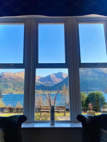 a window with a view of a lake and mountains at Creag Mhor Lodge in Onich