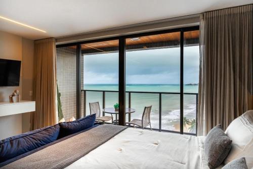 um quarto com uma cama e vista para o oceano em Apartamento em Maceio - Loft 1208 em Maceió